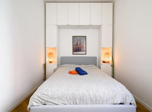 Le Balcon de la Comédie, Beau T3 Centre Historique في مونبلييه: غرفة نوم عليها سرير ابيض ومخدة زرقاء