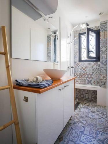 - une cuisine avec un évier et un bol sur un comptoir dans l'établissement Le Balcon de la Comédie, Beau T3 Centre Historique, à Montpellier