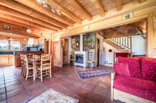 Il comprend une cuisine et un salon avec un canapé rouge et une table. dans l'établissement Chalet L'arba clar - 4 étoiles, à Morzine