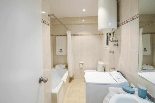 La salle de bains blanche est pourvue d'un lavabo et de toilettes. dans l'établissement Vista al mar con piscina en SAgaró, à Sant Feliu de Guíxols