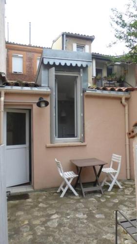 deux chaises et une table devant une maison dans l'établissement Apartement au calme, cour, près du métro, centre, à Toulouse