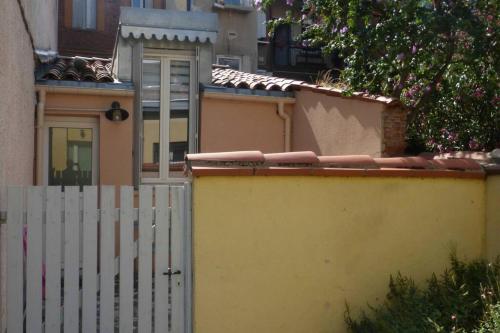 une clôture blanche à côté d'une maison avec un piquet blanc dans l'établissement Apartement au calme, cour, près du métro, centre, à Toulouse