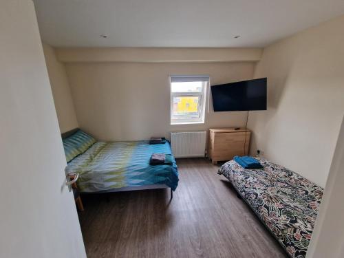 ロンドンにあるImpeccable 1-Bed Apartment in Londonのベッドルーム1室(ベッド2台、薄型テレビ付)