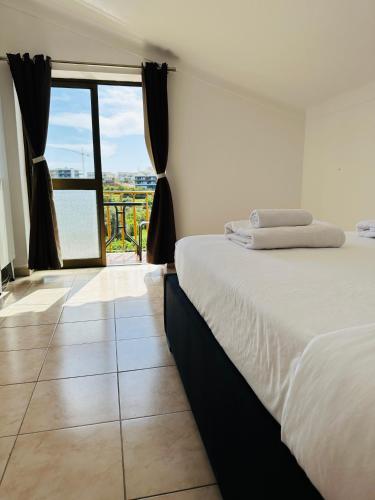 a bedroom with a bed and a large window at Portimao Central Holiday Guesthouse in Portimão