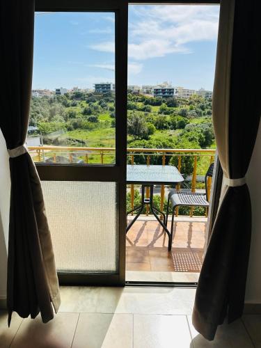 a room with a view of a balcony with a table at Portimao Central Holiday Guesthouse in Portimão