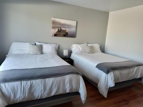 two beds sitting next to each other in a bedroom at Motel Cabano-Relais in Cabano