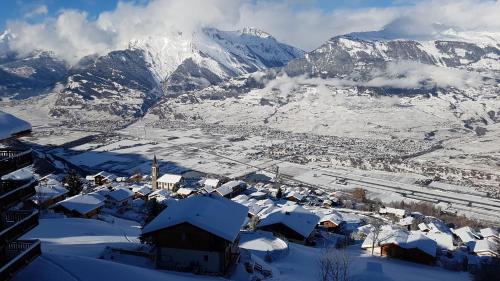 a village covered in snow with mountains in the background at Fontanettaz V 015 - MOUNTAIN apartment 6 pers in Veysonnaz