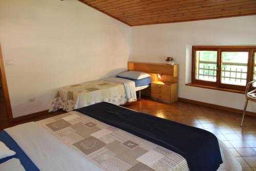 sypialnia z 2 łóżkami i oknem w obiekcie Residence Zecchini w mieście Ledro