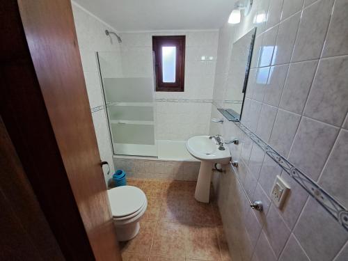 uma casa de banho com um WC, um lavatório e um chuveiro em Playas de Sol em Pinamar