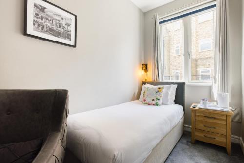 ロンドンにあるBorough High Street Roomsのベッドと窓のある小さな寝室