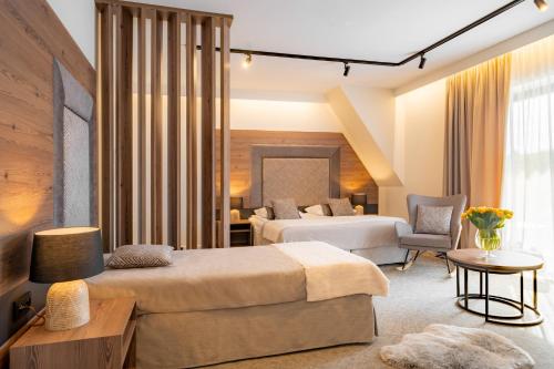 a hotel room with two beds and a chair at Termy Szaflary in Szaflary