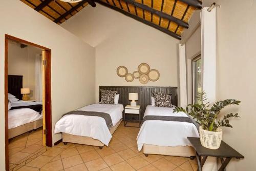 En eller flere senge i et værelse på Unyati Safari Lodge