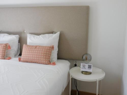a bed with two pillows and a side table at Casa dos Primos in Muxagata