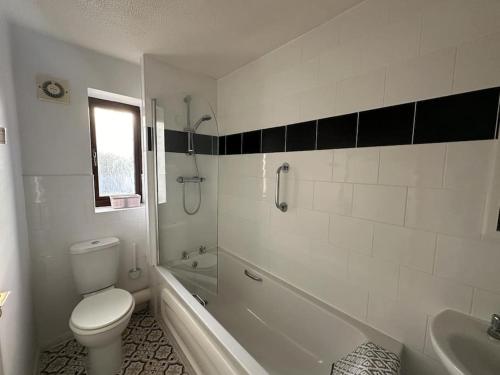 a bathroom with a toilet and a tub and a sink at Caroline's One Bedroom House in Northampton in Northampton
