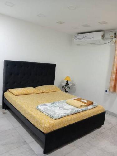 1 cama con cabecero negro en una habitación en Economique Rester @BanjaraHills, en Hyderabad