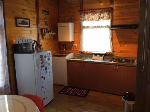 uma cozinha com um frigorífico branco e uma janela em Romantic Cabin Home ! em Bogotá