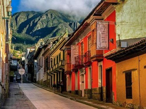 una calle vacía con edificios y montañas en el fondo en Romantic Cabin Home ! en Bogotá