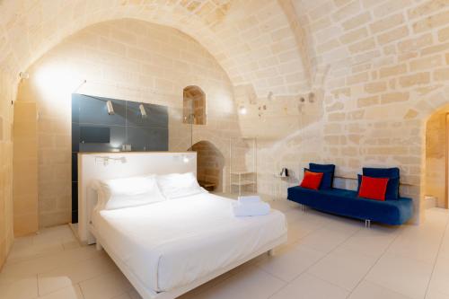a bedroom with a white bed and a blue couch at Endea Suite Rooms & Lounge SPA in Matera