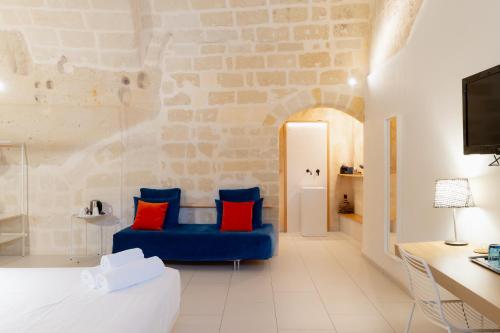 a bedroom with a blue couch with red pillows at Endea Suite Rooms & Lounge SPA in Matera