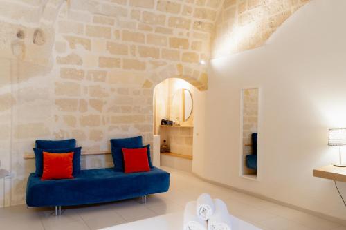 a living room with a blue couch with red pillows at Endea Suite Rooms & Lounge SPA in Matera