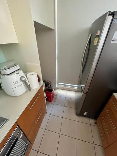 uma cozinha com um frigorífico e piso em azulejo em B em Sydney