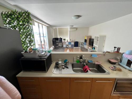 uma cozinha com um lavatório e um micro-ondas em B em Sydney