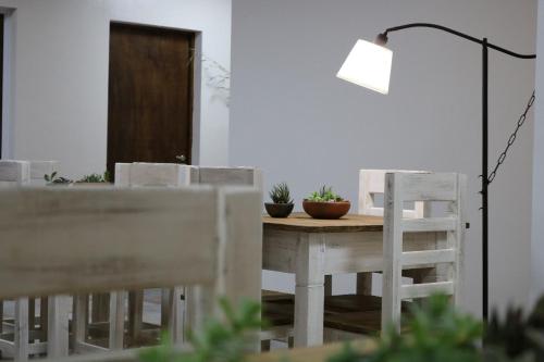 聖薩爾瓦多德胡胡伊的住宿－Hotel Quebrachales，餐桌、白色椅子和灯