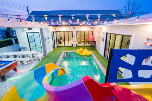 a backyard pool with a pool slide and a pool table at นาวาพูลวิลล่าหัวหิน VIP in Hua Hin