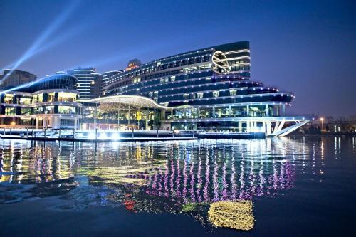 a large building with lights on the water at night at Crowne Plaza Suzhou by IHG in Suzhou