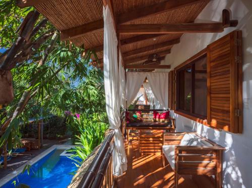 an outdoor patio with a hammock and a table and chairs at Black Bamboo in Puerto Viejo