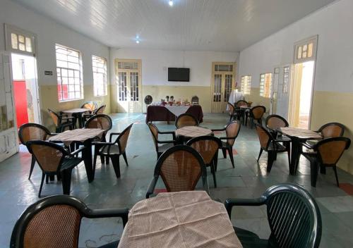 ein Esszimmer mit Tischen und Stühlen sowie einem TV in der Unterkunft Hotel Central in Araçatuba
