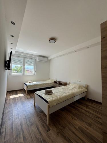 Habitación con 2 camas y TV. en Apartman Centar en Kuršumlija