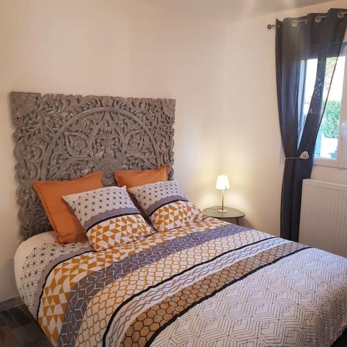 une chambre avec un grand lit avec des oreillers dessus dans l'établissement au p'tit bonheur, à Roye