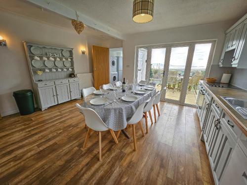 a dining room with a table and chairs in a kitchen at Raphael House in Burry Port