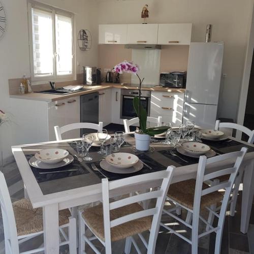 une cuisine avec une table avec des chaises et une salle à manger dans l'établissement au p'tit bonheur, à Roye