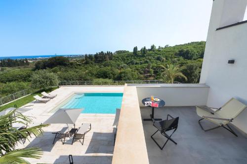 een villa met een zwembad en stoelen op een balkon bij Ferienhaus für 12 Personen in Nunziata, Sizilien Ostküste von Sizilien in Mascali