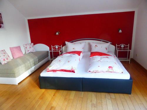 a bedroom with two beds and a red wall at Ferienhaus für 10 Personen in Vogelsgrün, Sachsen Vogtland in Bad Reiboldsgrün