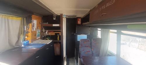 una cocina en una cabaña con barra y ventana en BusTel Hostel en Bus en Potrerillos