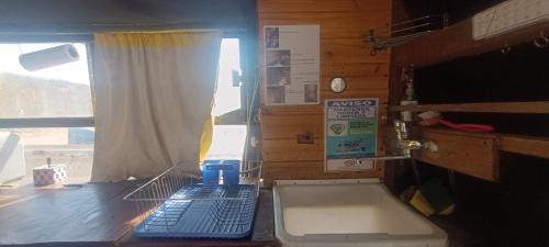 una cocina con teclado en una encimera con ventana en BusTel Hostel en Bus en Potrerillos