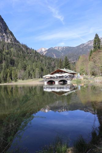 a bridge over a lake with mountains in the background at Zur alten Schmiede in Ettal