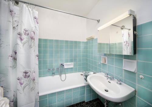 a bathroom with a sink and a tub and a shower at Ferienwohnung Spiess in Merano