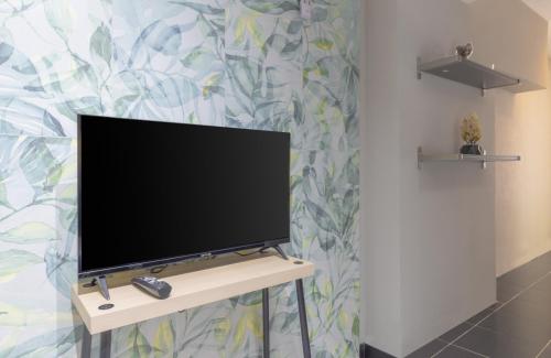 TV de pantalla plana sentada en un stand en una habitación en Уютные апартаменты, квартира в аренду, Анталия, Лара, en Antalya