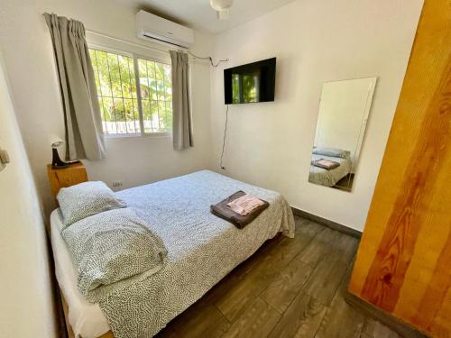 a small bedroom with a bed and a mirror at Mango House. Mono 2 bedrooms in Cabarete