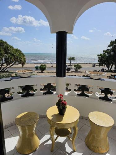 balcón con mesa y sillas y la playa en Brise de Mer Azur, en Yibuti