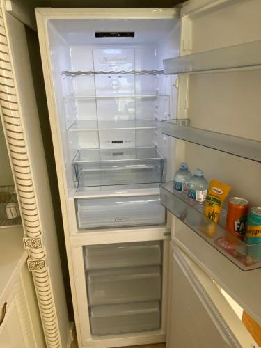 an empty refrigerator with its door open with drinks in it at Lux Apartment Meecoon Rafailovići in Rafailovici