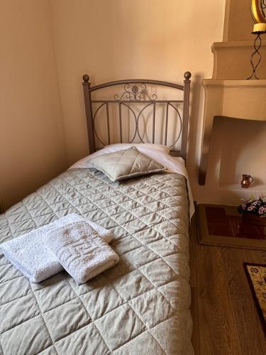 a bedroom with a bed with two towels on it at Kiwi Traditional House in Litochoro