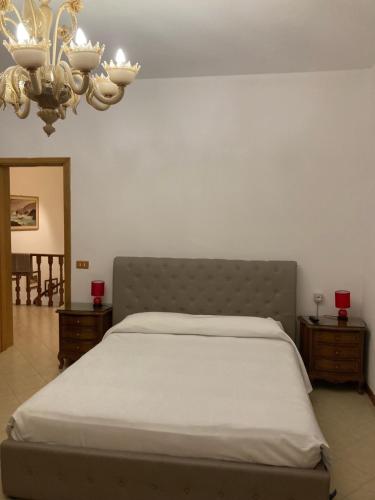 a bedroom with a bed and a chandelier at B&B La Terrazza Dell'Itria in Modica