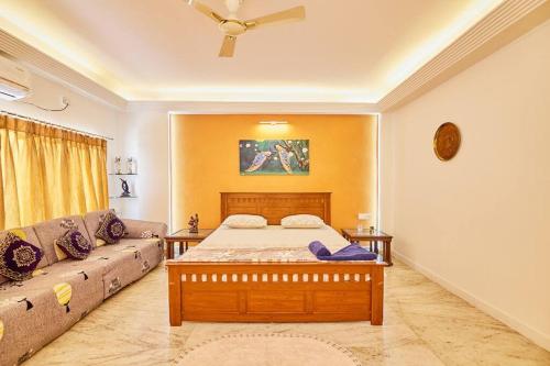 een slaapkamer met een bed en een bank bij RoofTop-1BHK for Families only @HimayathNagar in Hyderabad