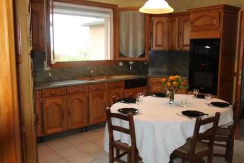 une cuisine avec une table et des chaises ainsi qu'une fenêtre dans l'établissement GITE CONFORT plain-pied 12 min d'Albi pas de vis-à-vis, à Andouque