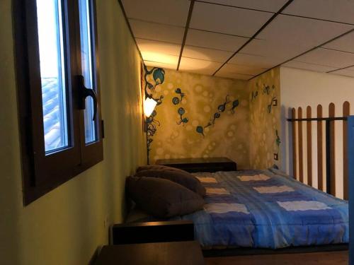 um quarto com uma cama num quarto com uma janela em Loft immerso nel bosco em Rivola
